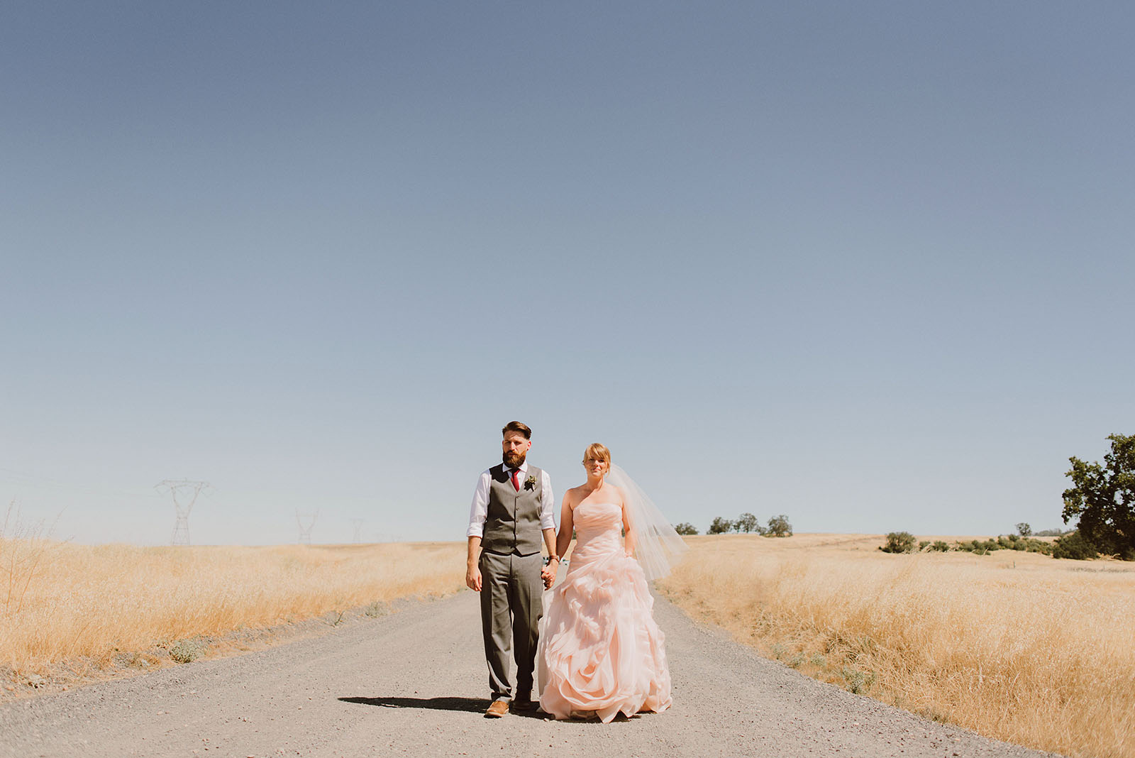 Bride and Groom walking down a road in Upper Bidwell Park | Backyard Chico California Wedding