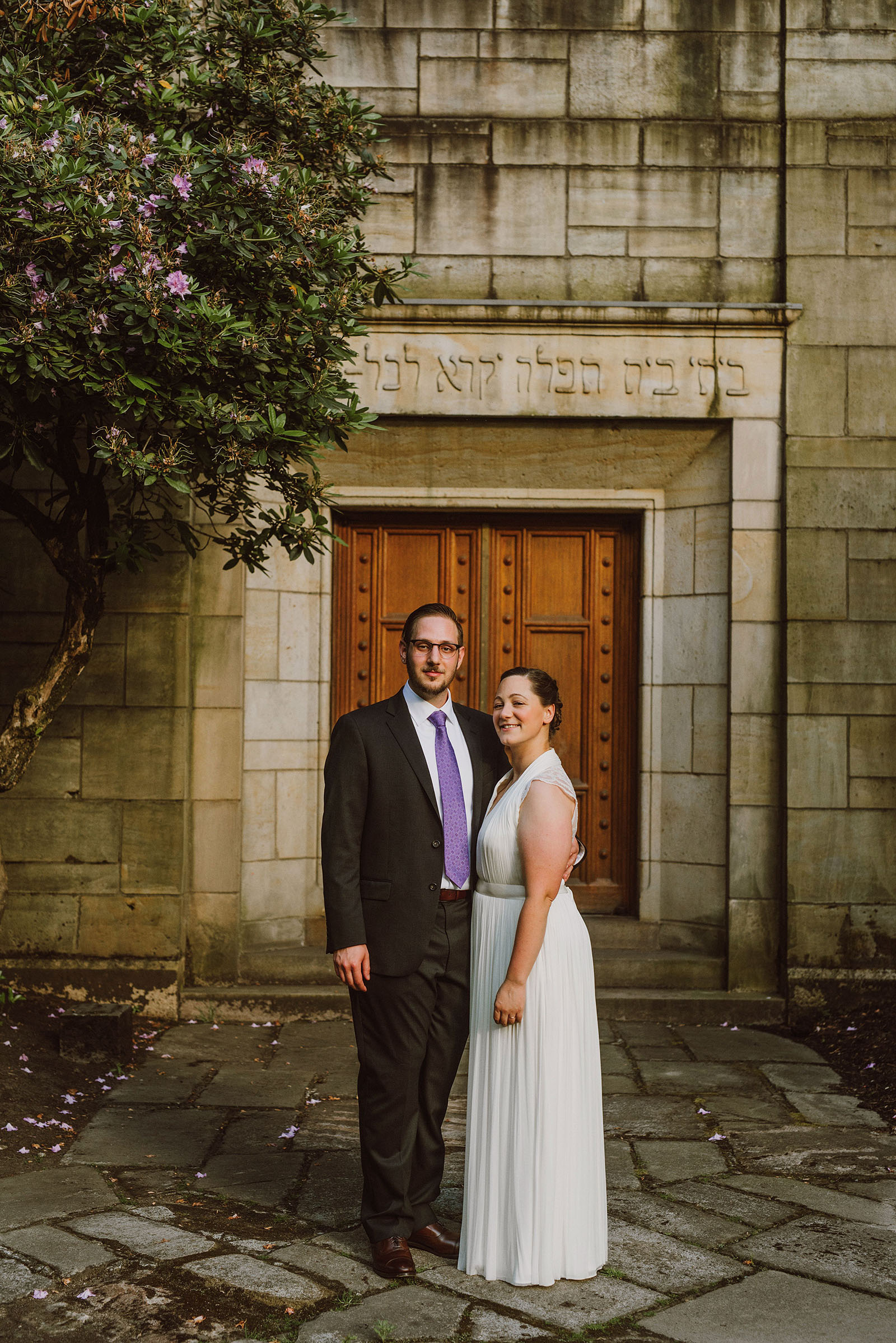 Bride and Groom posing in front of their Congregation Beth Israel wedding in Portland, OR
