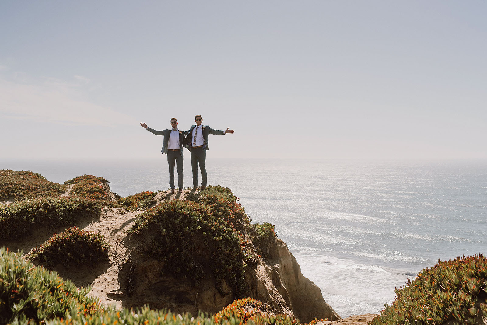 Grooms waving their arms at the San Francisco beach - Foreign Cinema Wedding