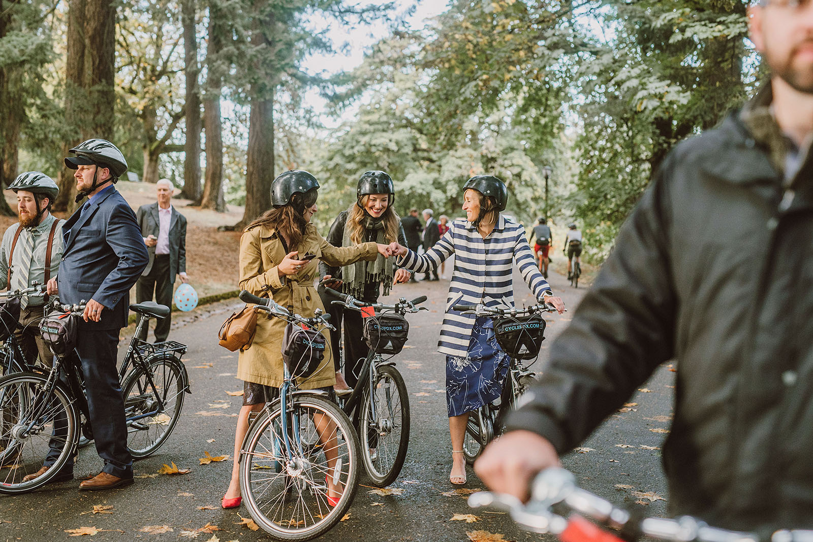 wedding guests fist bumping before a bike parade on Mt Tabor - portland wedding photography