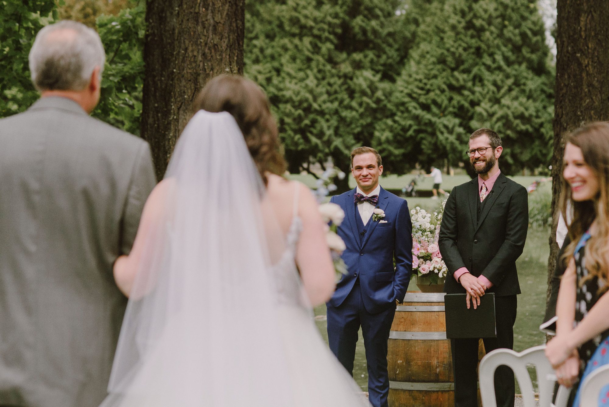 Groom seeing bride as she walks down the aisle at Crystal Springs Rhododendron Gardens