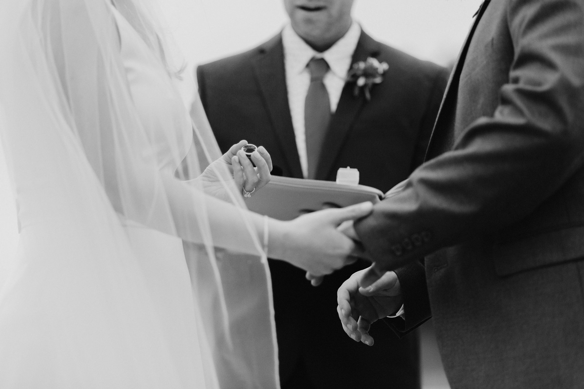 Bride holding ring during wedding ceremony on the Oregon Coast