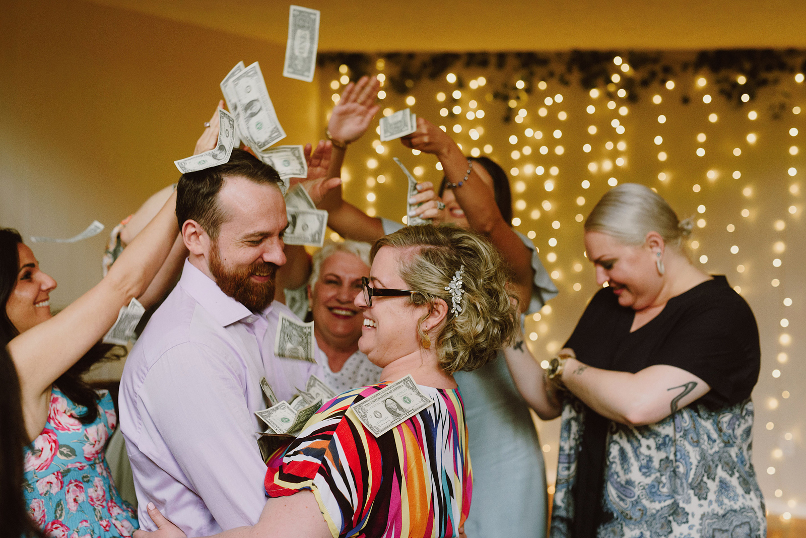 Bride and groom being showered with money by their friends and family during the first dance - Oaks Pioneer Church Wedding